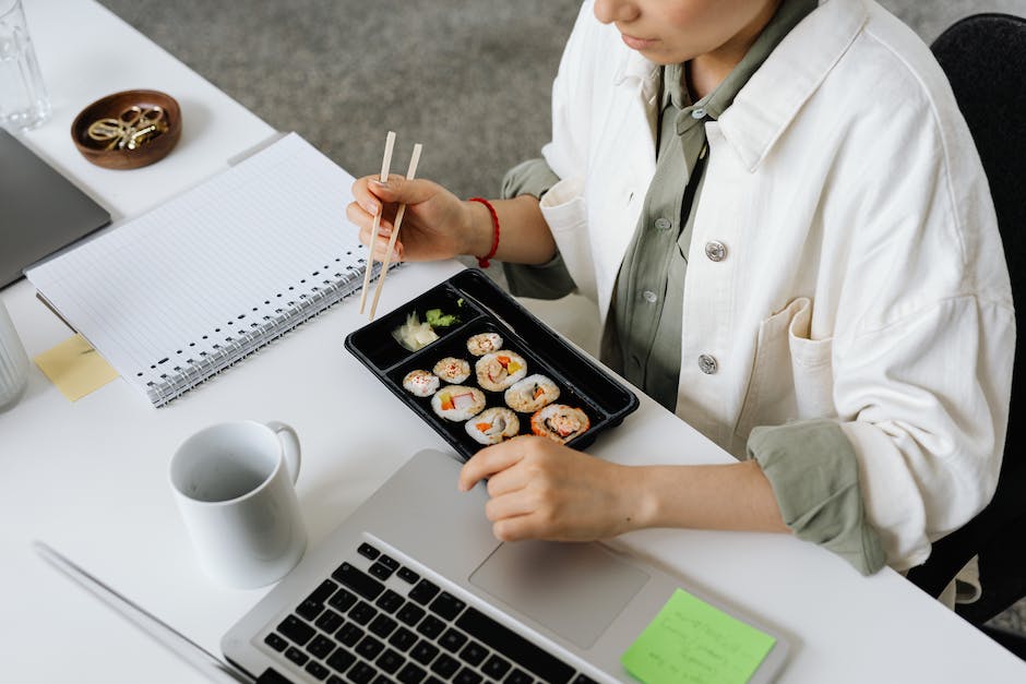 Image of person using chopsticks to eat sushi