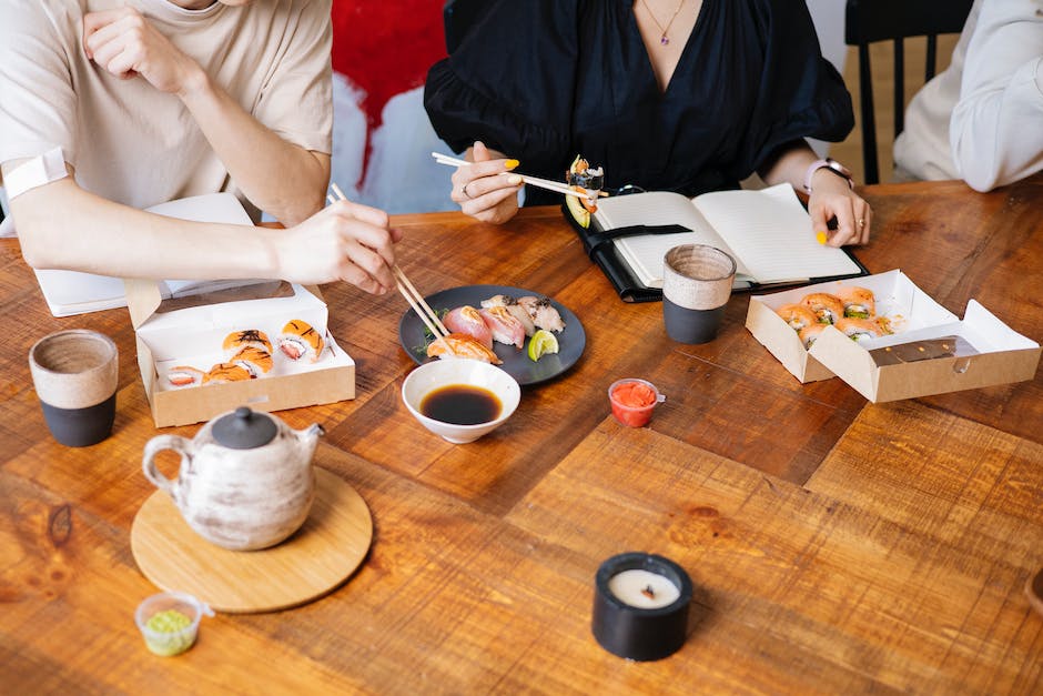 Ilustración de una persona comiendo sushi con palillos y sumergiéndolo ligeramente en salsa de soja. La imagen representa el respeto y el aprecio por la etiqueta del sushi.